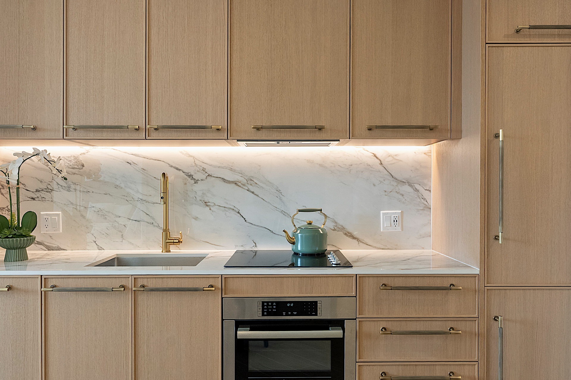 Kitchen with marble backsplash and brass fixtures